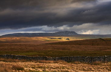 Storm clouds and sunshine over the Three Peaks Summit of Pen-y-ghent near Horton in Ribblesdale in...