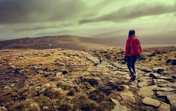 A hiker descending the summit of Ingleborough towards Simon Fell in the Yorkshire Dales, England.