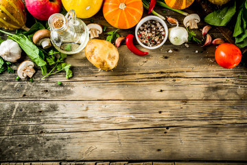 Fototapeta na wymiar Autumn food concept. Healthy organic harvest vegetables and ingredients pumpkin, greens, tomatoes, corn, wooden kitchen table background. Thanksgiving seasonal cooking ingredients.