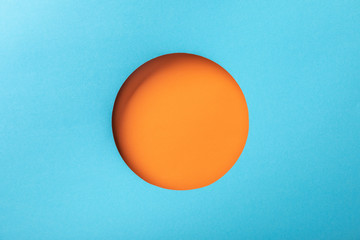 creative background with blue paper and round orange hole