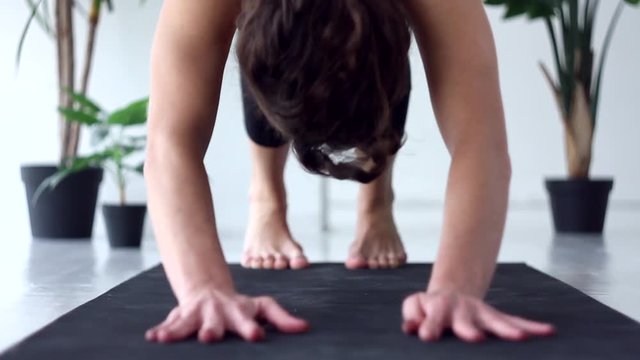 Closeup young woman is doing exercise asanas complex of diamond, downward facing dog, four limbed staff, child poses. Athletic female in black uniform is practicing yoga. Healthy lifestyle concept.