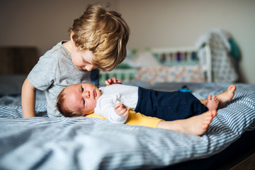 A small boy with a newborn baby brother at home.