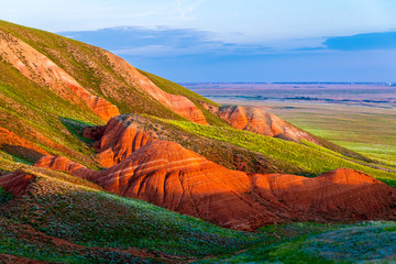 Big Bogdo mountain. Red sandstone outcrops on the slopes sacred mountain in Caspian steppe Bogdo -...