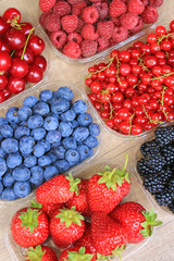 Mix of fresh berries on wooden background, strawberry, blueberry, raspberry,  blackberry, cherry and red currant