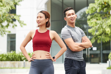 Positive fitness trainers in sports clothes standing outdoots
