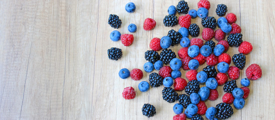 Mix of fresh berries on wooden background, blueberry, raspberry, blackberry