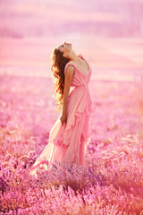 Fototapeta na wymiar beautiful young girl walks in a field of lavender