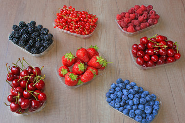 Mix of fresh berries on wooden background, strawberry, blueberry, raspberry,  blackberry, cherry and red currant