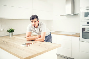 Fototapeta na wymiar Young man in home kitchen with tablet