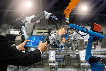 Manager engineer touch screen control automation robot arms the production of factory parts engine...