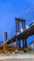 Night view of the Empire State Building through the pylons of Manhattan Bridge. View from Washington Street in Dumbo