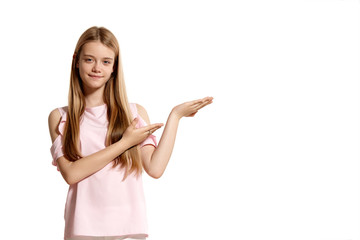 Studio portrait of a beautiful girl blonde teenager in a pink t-shirt posing isolated on white background.