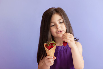 Cute little child girl eting strawberry. Vitamin healthy food. Summer time