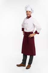 Positive handsome chef cook in beret and white outfit isolated on white background.