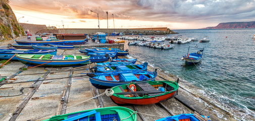 Scilla coastline and boats in Chianalea at sunset, Calabria, Italy