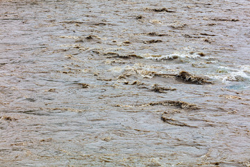 Dirty water runs in a mountain river