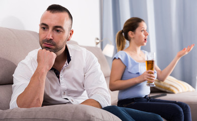 Man is sading when his wife is watching TV
