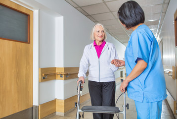 Fototapeta premium Caregiver assisting senior retired woman at hospital
