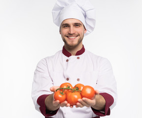 Food service, organic food, healthy diet, cooking and professional culinary concept - chef in white uniform holds vegetables.