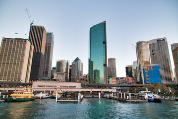 Fototapeta na wymiar SYDNEY - AUGUST 18, 2018: City Harbor and buildings on a beautiful afternoon. Sydney attracts 20 million tourists annually