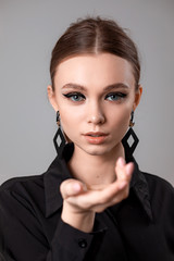 Fototapeta premium Beautiful young woman with make-up in a black shirt
