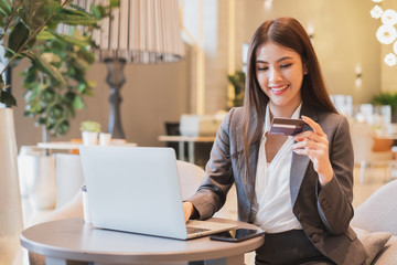 Asian businesswoman using credit card and mobile phone for online financial payment and shopping