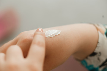 Skin care. Woman applying daily care cream to her hands in home.