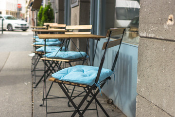 Summer terrace cafe. Empty tables and chairs. Garden furniture. Furniture cushions. Empty seats in...