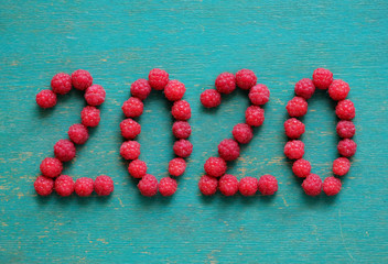 happy new year 2020 made of berries on a blue wooden background