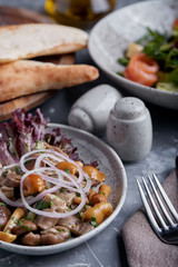 marinated mushrooms and onions in a plate on a grey background