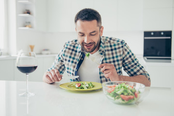 Portrait of charming imposing man hold hand silverware knife fork sit table enjoy meal morning...