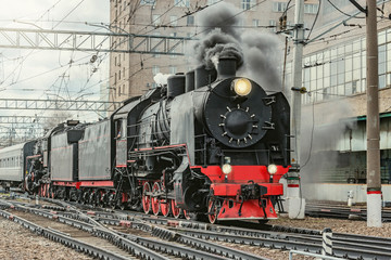 Fototapeta na wymiar Retro train departs from Kazan railway station building. Moscow.