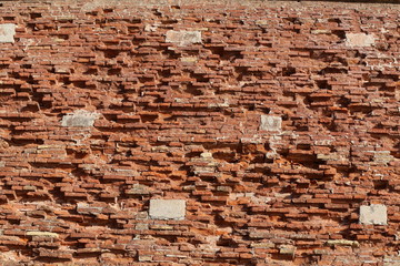The old red brick fortress wall is crumbling
