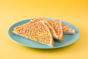 Traditional Australian fairy bread on yellow  background