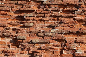 The old red brick fortress wall is crumbling