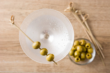 Classic Dry Martini with olives on wooden table. Top view