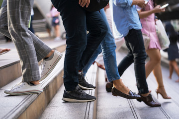 Naklejka premium Close up of legs and shoes walking on street in the city