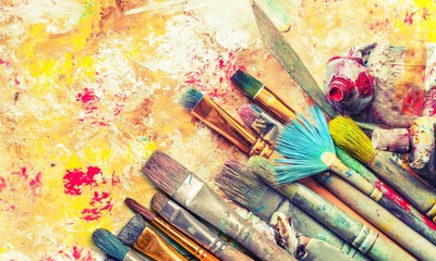 Row of artist paint brushes on art background