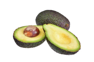 Ripe dark avocado and avocado cut in two halves with a brown stone on a neutral white background