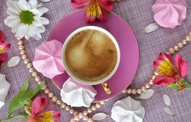 The layout in pink colors on the theme of luxury rest with coffee, sweets, flowers and pearl beads closeup