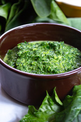 Healthy vegetarian or vegan food, cooked green spinach with cream, ingredient for many dishes like pasta, ravioli or soup