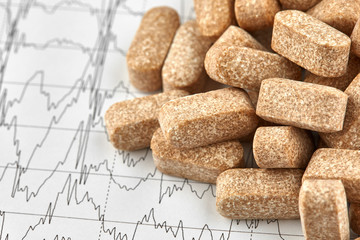 Close-up photo of many brown pills on EKG graph
