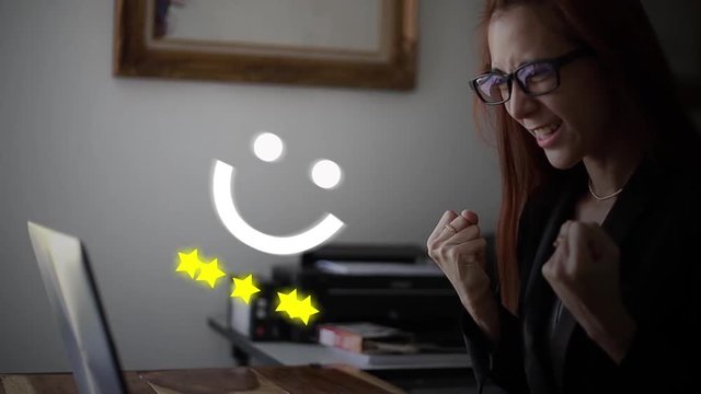 Businesswoman Sitting at the Desk Using Laptop Finishes Project and Wins Big. Makes Successful Gestures Raises Arms in Celebration.