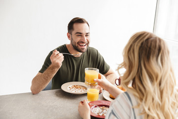 Happy young loving couple posing at the kitchen at home have a breakfast.