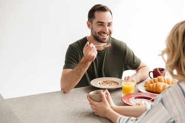 Happy young loving couple posing at the kitchen at home have a breakfast.