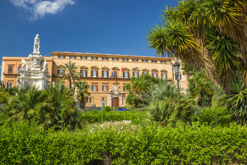 Obraz premium Wide beautiful view of famous Norman palace in Palermo Sicily, green garden with palms, historic statues and royal palace