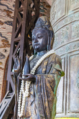 Obraz premium Ancient bronze statue with beads of pearls in temple