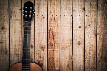 Acoustic guitar on vintage style wood background. Copy space with musical guitar instrument