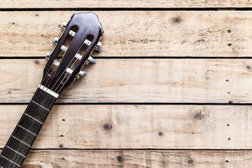 Acoustic guitar on vintage style wood background. Copy space with musical guitar instrument