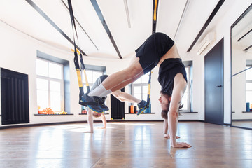 Obraz premium Athletes for men the coach and the student work out in the gym with the help of exercises with full resistance. Concept of the will to victory and the desire to be first